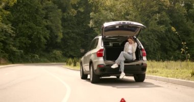 Broken down car on a road with red warning triangle. Flat tire problem.