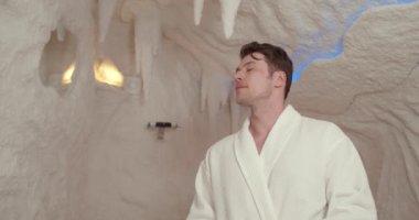 A young man is resting in the salt room. Spa treatments for men with respiratory disorders, inhalation.