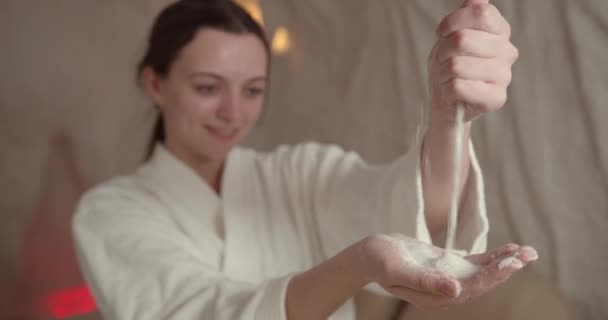 温泉サロンで塩を手にした女性 女性は塩室で治療を楽しんでいます ハレー療法 — ストック動画