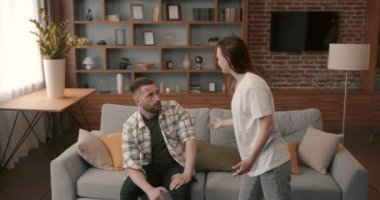 Irritated young woman screams in frustration offends abases her stressed disappointed husband. Domestic violence, abuse.
