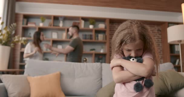 両親が家で喧嘩や喧嘩をしている間 白人の少女はソファに座って泣いていました 子供はおもちゃや家庭内暴力の概念を抱き — ストック動画