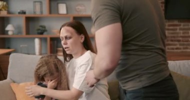 Domestic violence concept. Man and woman fighting in the living room, bruised woman.