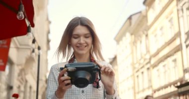 Young woman, tourist is taking photos of her boyfriend on camera, enjoying her adventure in Europe.