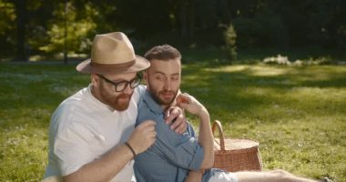 Smiling two men gay hugging on field at park. Spending time together. Feel free and happy. LGBT Representatives. Slow motion.