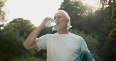 Fitness, garden and a senior man with water bottle, exercise and hydrate in retirement. Health, nature and workout.