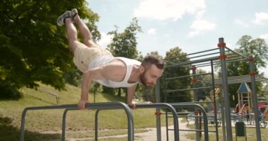 Genç sporcu paralel barlarda alıştırma yapıyor. Aktif yaşam tarzı. 4K.