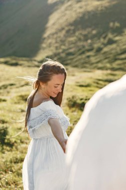 Dağlarda bir kadın ve bir erkek. Gün batımında aşık genç bir çift. Mavi elbiseli kadın..