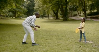 Happy affectionateb lack race family. Father playing with little daughter and walking in the park. Dad and cute child girl enjoy spending time together on outdoor weekend vacation.