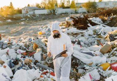 Çöp kutusunda tulumlu bir adam. Araştırma yapıyordum. Ekoloji kavramı, çevre kirliliği.