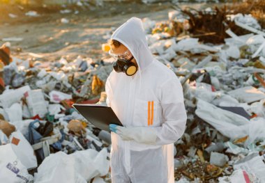 Çöp kutusunda tulumlu bir adam. Araştırma yapıyordum. Ekoloji kavramı, çevre kirliliği.