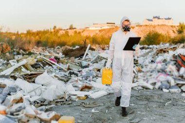 Çöp kutusunda tulumlu bir adam. Araştırma yapıyordum. Ekoloji kavramı, çevre kirliliği.