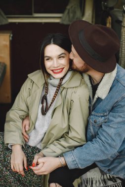 Kırmızı dudaklı bir kadına odaklan. Moda elbiseli romantik bir çift sarılıyor. Ceketli bir adam ve kadın ceketi..