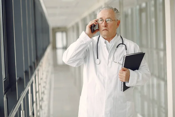 Senior in a hall. Doctor in a uniform. Man in a glasses.