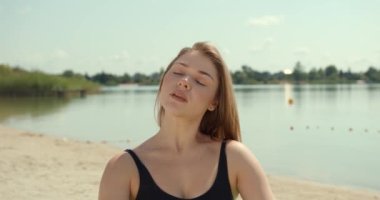 Genç bir kadın yoga minderinde gölde dinleniyor, yoga yapıyor, egzersiz yapıyor ve dinleniyor. Yaz güneşli hava, 4k.