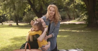 Güzel ve mutlu bir çift beyaz lezbiyen ekose üzerinde oturup tatlı kızıyla temiz havada eğleniyorlar. Aile zamanı kavramı, lgbt insanları ve yaşam tarzları.