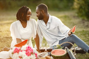 Kaygısız, rahat bir çift pikniğin tadını çıkarıyor. Karpuz yiyorlar..