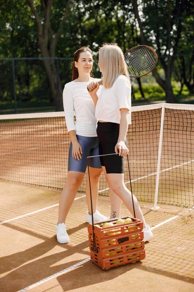 テニスコートにはラケットとボールの箱を持つ女性の友人 夏外の法廷 — ストック写真