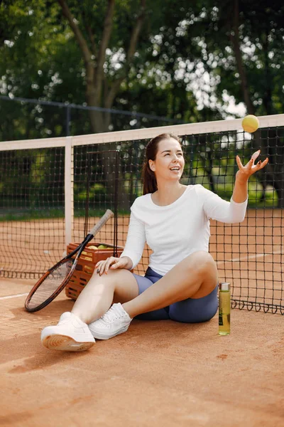 テニスコートでネットに座っている女性 試合後休んでる スポーツの概念 — ストック写真