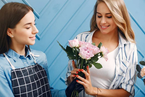 Florist with flowers. Woman makes a bouquet. Girl buys a bouquet