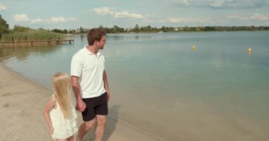 Genç bir baba ve küçük bir kız göl kenarında bir tatilde. Ebeveyn ve çocuk aile tatili yapıyor..