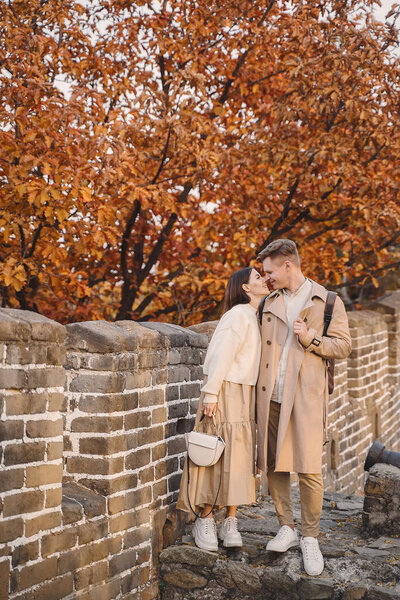 young couple kissing at the Great Wall of China. Newly married couple on their honeymoon to the Great Wall of China near Beijing China.