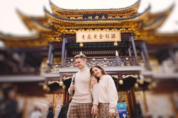 新婚夫婦は元の近くの上海で愛情を示しています カップルは中国を訪問している間にいくつかの抱擁の休憩を取る 夫と妻が市場や塔の前で手を取り合って — ストック写真
