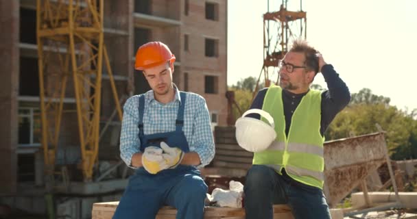 Trabajadores Construcción Hombres Caucásicos Con Chaquetas Seguridad Cascos Hablando Sentado — Vídeos de Stock