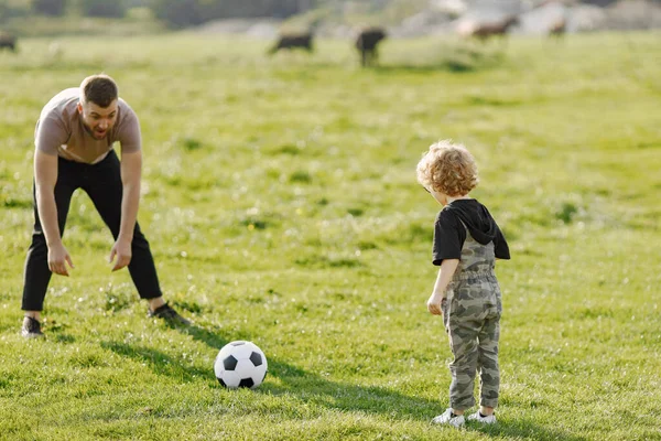 一个白人爸爸和一个小孩一起玩 一起笑 爸爸和儿子一起玩球 在室外的夏季公园里玩得很开心 毛茸茸的蹒跚学步的男孩 全身穿着卡其布的衣服 — 图库照片