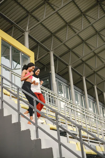 Stadyumda Merdivenlerden Inen Iki Kadın Beyaz Gömlek Kırmızı Pantolon Giyen — Stok fotoğraf