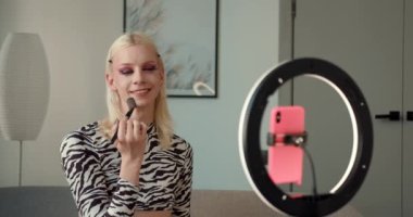 Makyaj yapan ve LGBT temalı canlı bir video yayınlayan yakışıklı bir gay 'in orta boy yakın çekim görüntüsü. Yüksek kalite 4k görüntü.