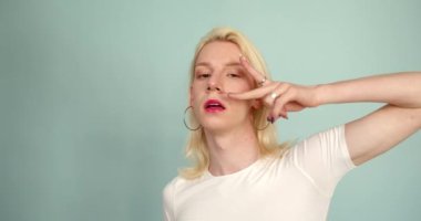 Androgyny. Makyajlı transseksüel adam arka planda poz veriyor. Bir insanda erkeksi ve kadınsı özellikler. Cinsiyet kimlik kavramı, 4k.