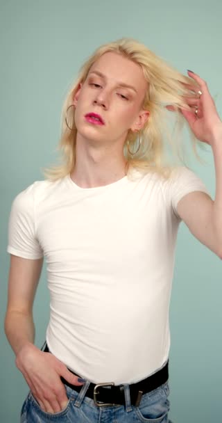 アンジィ メイクを背景にポーズをとったトランスジェンダーの男 男性的特徴と女性的特徴を1人で持つ 性同一性概念4K — ストック動画