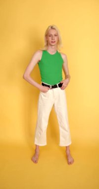 Androgyny. Yeşil bluzlu transseksüel adam arka planda poz veriyor. Bir insanda erkeksi ve kadınsı özellikler. Cinsiyet kimlik kavramı, 4k.