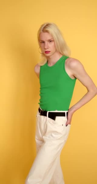 アンジィ 背景にポーズを取る緑色のトップのトランスジェンダーの男 男性的特徴と女性的特徴を1人で持つ 性同一性概念4K — ストック動画