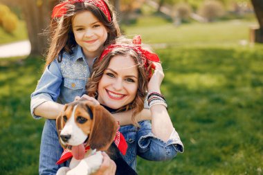 Kızı olan güzel bir anne. Bir bahar parkında aile. Mavi gömlekli kadın. Sevimli bir köpek ile Aile