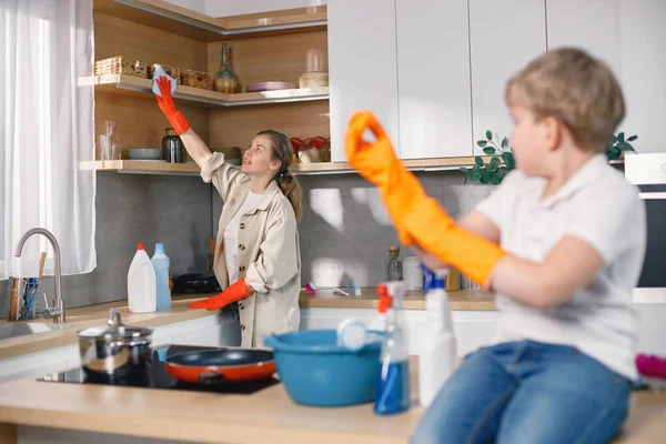 Ξανθό Αγόρι Και Ενήλικη Γυναίκα Καθαρίζουν Στην Κουζίνα Και Φοράνε — Φωτογραφία Αρχείου