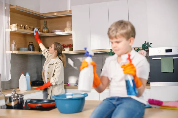 Blondynka Dorosła Kobieta Sprzątająca Kuchni Nosząca Pomarańczowe Rękawiczki Biały Chłopiec — Zdjęcie stockowe