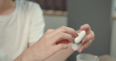 Kızıl saçlı hoş bir bayan evde çalışıyor ya da ders çalışıyor. Masaüstünde oturuyor ve kablosuz kulaklık kullanıyor..