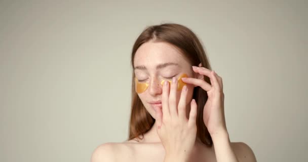 Söt Tjej Som Applicerar Gyllene Kollagenplåster Ögonen Kvinnlig Ansiktsbehandling Kosmetologi — Stockvideo