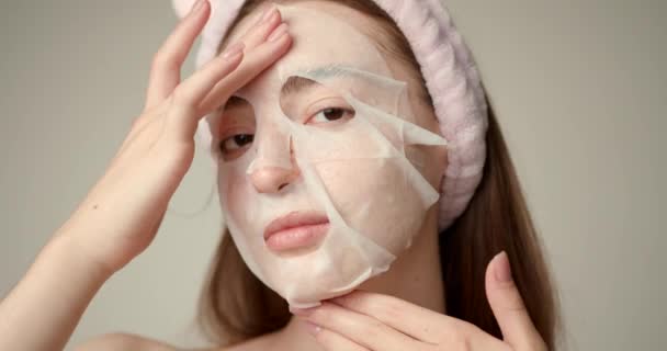 フェイスマスクを適用するかわいい女の子 女性の顔の治療 — ストック動画