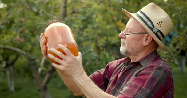 Χαμογελαστός Εργάτης Αγρότης Που Δείχνει Χυμό Μήλου Γυάλινο Μπουκάλι Στον — Αρχείο Βίντεο