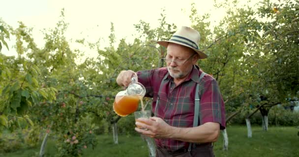 Trabalhador Agricultor Masculino Sorridente Mostrando Suco Maçã Garrafa Vidro Jardim — Vídeo de Stock