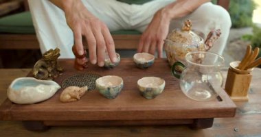 Genç bir adam geleneksel Çin çay seremonisi sanatını öğreniyor. Bambu tepsisinde özel bir cam kasede olgunlaşmış çiğ çay demler.