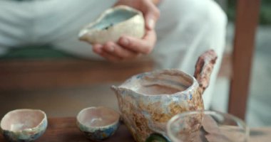 Genç bir adam geleneksel Çin çay seremonisi sanatını öğreniyor. Bambu tepsisinde özel bir cam kasede olgunlaşmış çiğ çay demler.