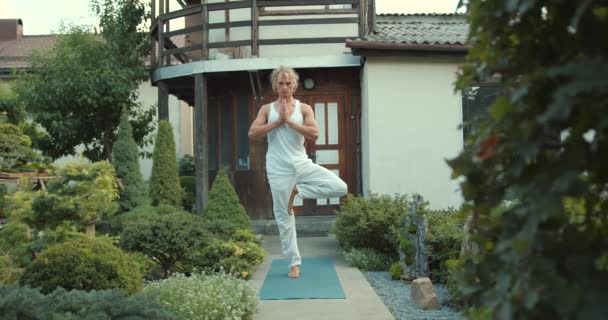 Man Utövar Yoga Matta Utomhus Orientaliska Huset Killen Vit Topp — Stockvideo