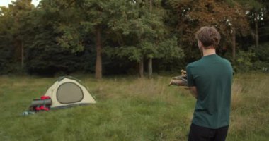 Ormanda odunları tutan adam. İnsanlar, yaz, turizm ve doğa konsepti.