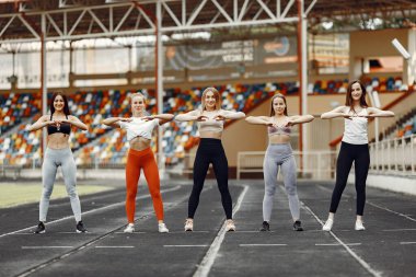 Beautiful girls at the stadium. Sports girls in a sportswear.