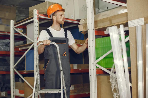 stock image Industrial worker indoors in factory. Young technician with orange hard hat.