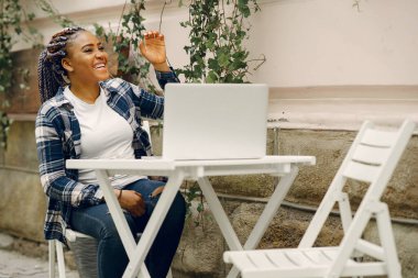 Genç, esmer, çekici üniversite öğrencisi. Güneşli bir günde masada oturan bir kadın. Dizüstü bilgisayarla tezini hazırlayan kız..