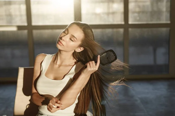 Wanita Muda Duduk Kursi Dan Menyikat Rambutnya Dengan Sisir Wanita — Stok Foto